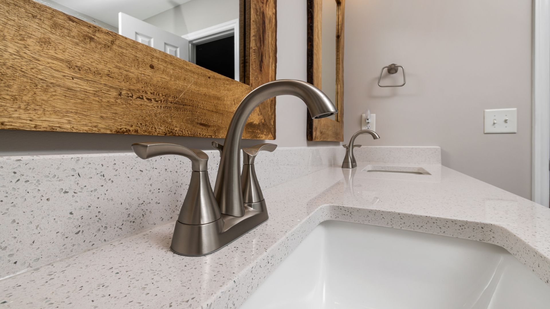 Modern bathroom sink with brushed nickel faucet and wooden accent wall